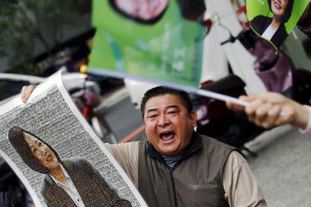 A supporter shouts among pictures of Taiwan's Democratic Progressive Party (DPP) Chairperson and presidential candidate Tsai Ing-wen as her campaign motorcade passes by, in New Taipei City, Taiwan January 13, 2016. REUTERS/Damir Sagolj