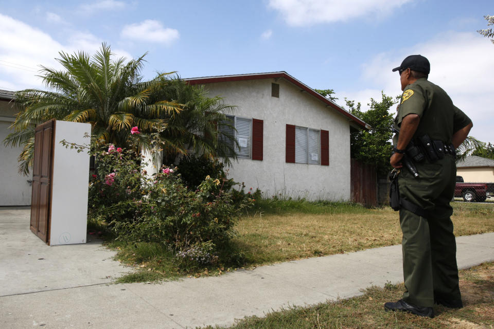 El ayudante del sheriff del Condado de Orange, Dan Mendoza, mira una casa embargada que tiene que desalojar en Fullerton, California, el 23 de junio de 2009. REUTERS/Lucy Nicholson (SOCIEDAD DE NEGOCIOS DE LOS ESTADOS UNIDOS)