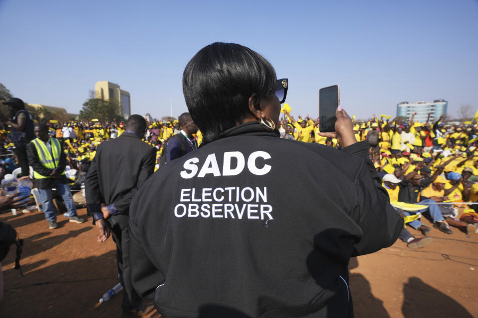 An election observer takes pictures at an opposition campaign rally in Harare, Monday, Aug. 21, 2023. Zimbabwe's main opposition leader Nelson Chamisa is surrounded by security as he leaves his last campaign rally in Harare, Monday, Aug 21, 2023. The upcoming general election in Zimbabwe is crucial to determining the future of a southern African nation endowed with vast mineral resources and rich agricultural land. But for many in the educated but underemployed population, the daily grind to put food on the table inhibits interest in politics. (AP Photo/Tsvangirayi Mukwazhi)