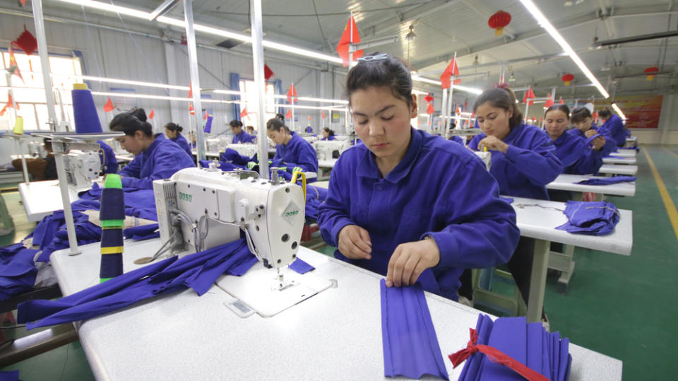 一名維吾爾族女人在和田縣的一間布廠工作。
