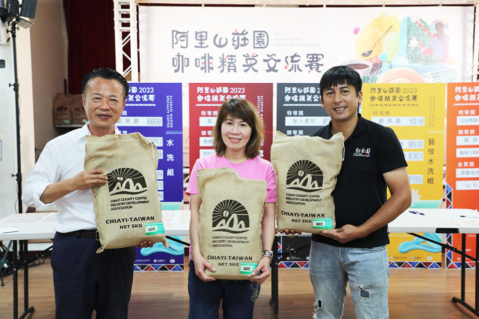 拍賣官翁章梁將(左)藝伎水洗組特等獎鄒築園咖啡豆以26萬的高價拍出。（記者張翔翻攝）