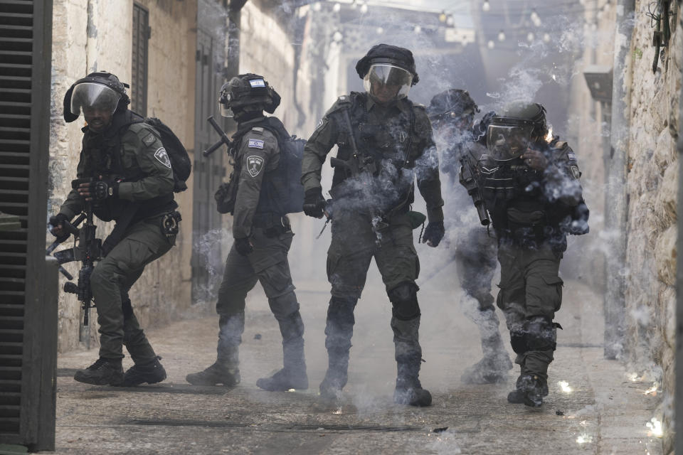 Palestinians shoot fireworks at Israeli police in the Old City of Jerusalem, Sunday, April 17, 2022. Israeli police clashed with Palestinians outside Al-Aqsa Mosque after police cleared Palestinians from the sprawling compound to facilitate the routine visit of Jews to the holy site and accused Palestinians of stockpiling stones in anticipation of violence. (AP Photo/Mahmoud Illean)