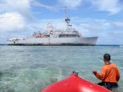 This photo, taken on January 22, 2013 by Philippine Coast Guard (PCG), shows a coast guard wading through water as he tugs a boat towards the US navy minesweeper, USS Guardian, which remains trapped at the Tubbataha reef off the western island of Palawan after it ran aground on January 17