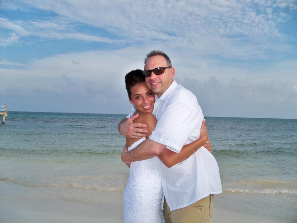 This May 13, 2013 image provided by Azia Wiscombe Ludwig shows Ludwig with her father, Clifford Robert Wiscombe II, shortly after her wedding in Playa del Carmen, Mexico. Ludwig's father died from a fall at a Mexican hotel, and Ludwig says the complicated logistics of repatriating his remains added to her grief and shock. Thousands of Americans die while traveling abroad each year _ including actor James Gandolfini, who died in Italy _ and the process of bringing their bodies home can include hassles ranging from bureaucratic hurdles to high fees. (AP Photo/Azia Wiscombe Ludwig)
