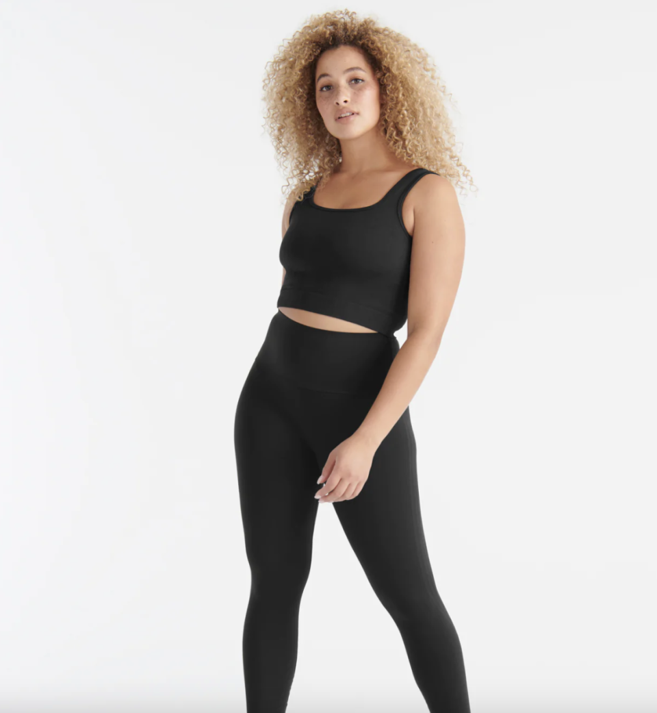 woman with curly afro wearing black leggings and Good to Go Seamless Crop Tank in Black (photo via Knix)