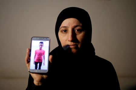 The mother of Palestinian teenager Mohammad Ayoub, who was killed during a protest at the Israel-Gaza border fence, shows his picture on a mobile phone at her house in Gaza February 28, 2019. REUTERS/Mohammed Salem