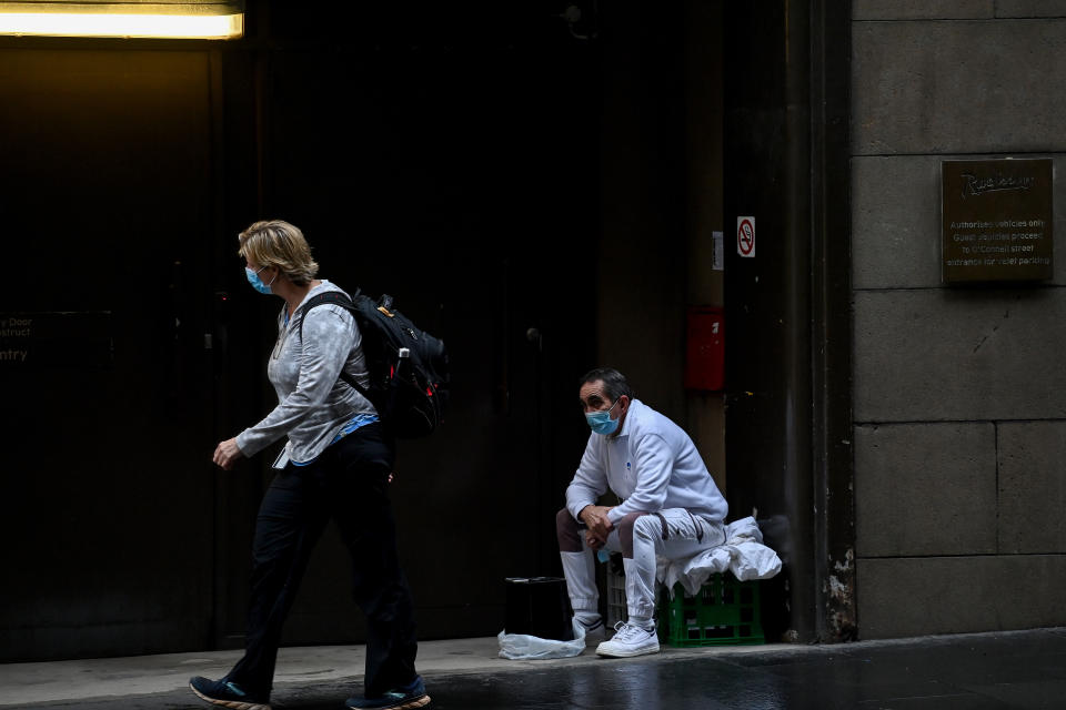 Two people wearing face masks on a Sydney street as Covid-19 continues to run rampant in the city.