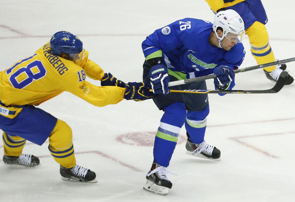 Sweden forward Jakob Silfverberg tries to slow down Slovenia forward Jan Urbas in the second period of a men's ice hockey game at the 2014 Winter Olympics, Wednesday, Feb. 19, 2014, in Sochi, Russia. Sweden won 5-0. (AP Photo/Mark Humphrey)