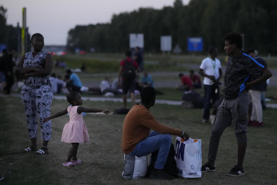 Hundreds of migrants who seek shelter prepare to spend the night outside an overcrowded asylum seekers center in Ter Apel, northern Netherlands, Thursday, Aug. 25, 2022. (AP Photo/Peter Dejong)