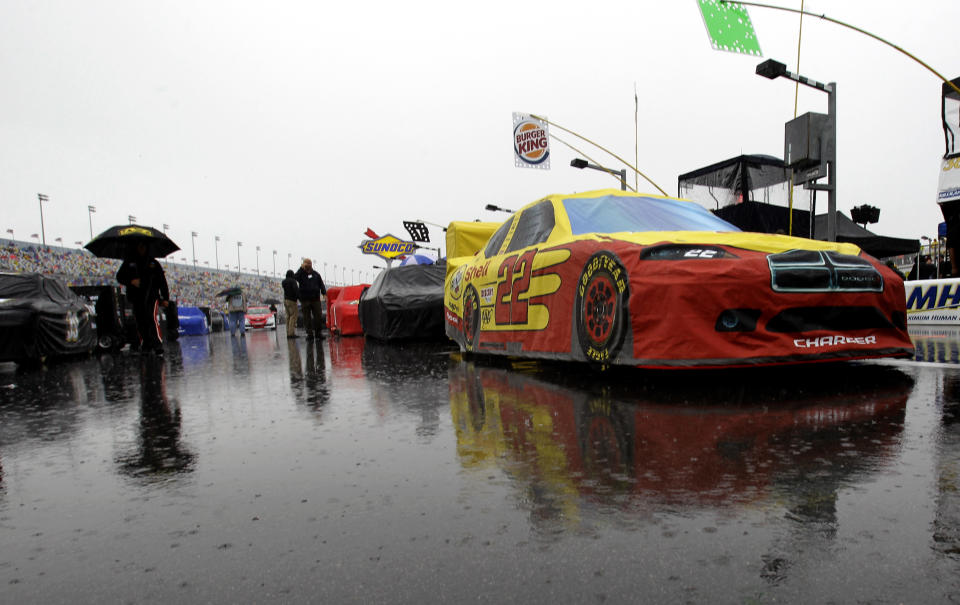 AJ Allmendinger's car (22) and others remain parked on pit road due to a rain delay before the start of the Daytona 500 auto race at Daytona International Speedway in Daytona Beach, Fla., Sunday, Feb. 26, 2012. (AP Photo/John Raoux)