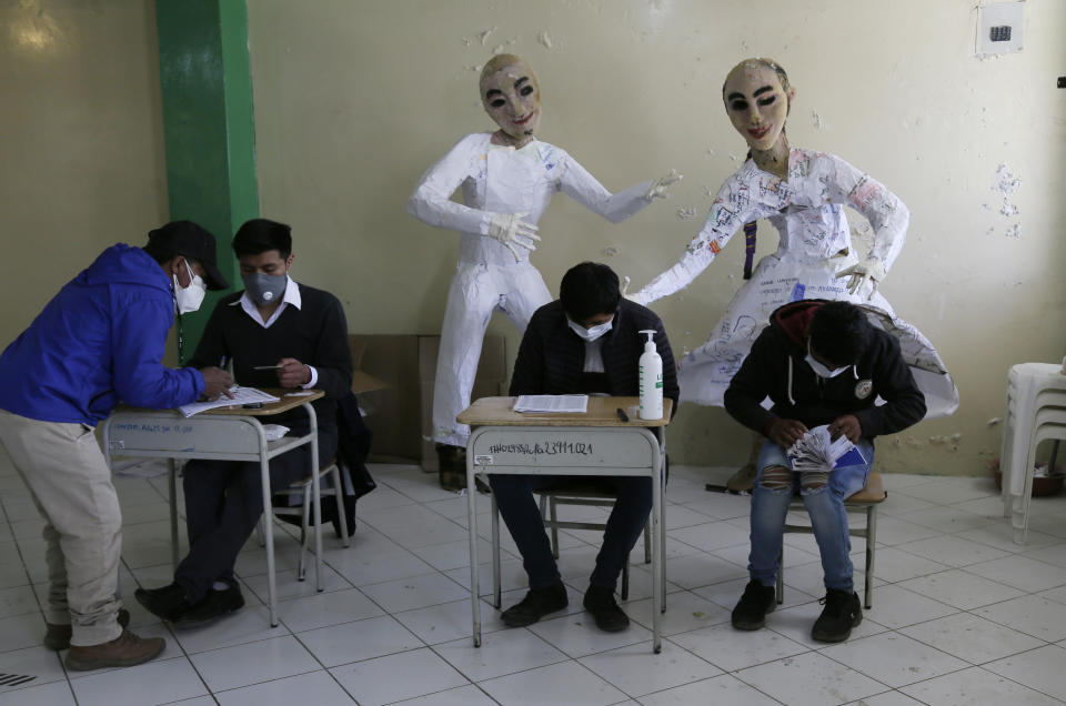 A man signs a roster after casting his ballot at a school in Cangahua, Ecuador, Sunday, Feb. 7, 2021. Ecuadoreans went to the polls in first-round presidential legislative elections. (AP Photo/Dolores Ochoa)