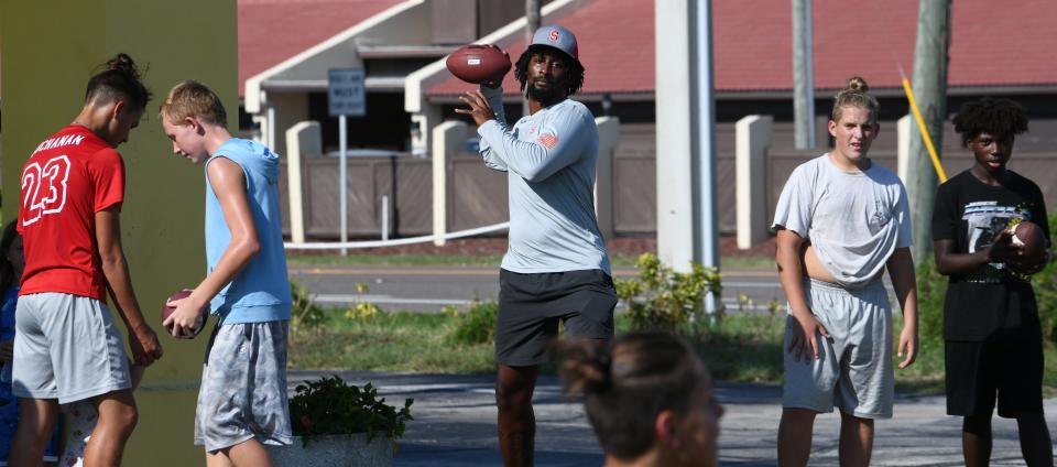  Late afternoon football. Malyk Steward, 24, an athletic trainer, gives his time and talents after work to help train kids in football at Americas Best Value Inn, located on A1A in South Patrick Shores.