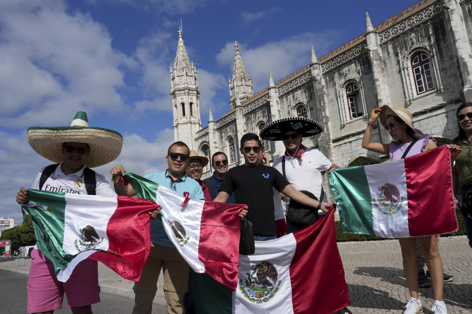 World Youth Day pilgrims from Mexico pose with their national flags outside the 16th century Jeronimos monastery, in the background, in Lisbon, Tuesday, Aug. 1, 2023. Pope Francis will visit the monastery when he arrives Aug. 2 to attend the international event that is expected to bring hundreds of thousands of young Catholic faithful to Lisbon and goes on until Aug. 6. (AP Photo/Ana Brigida)