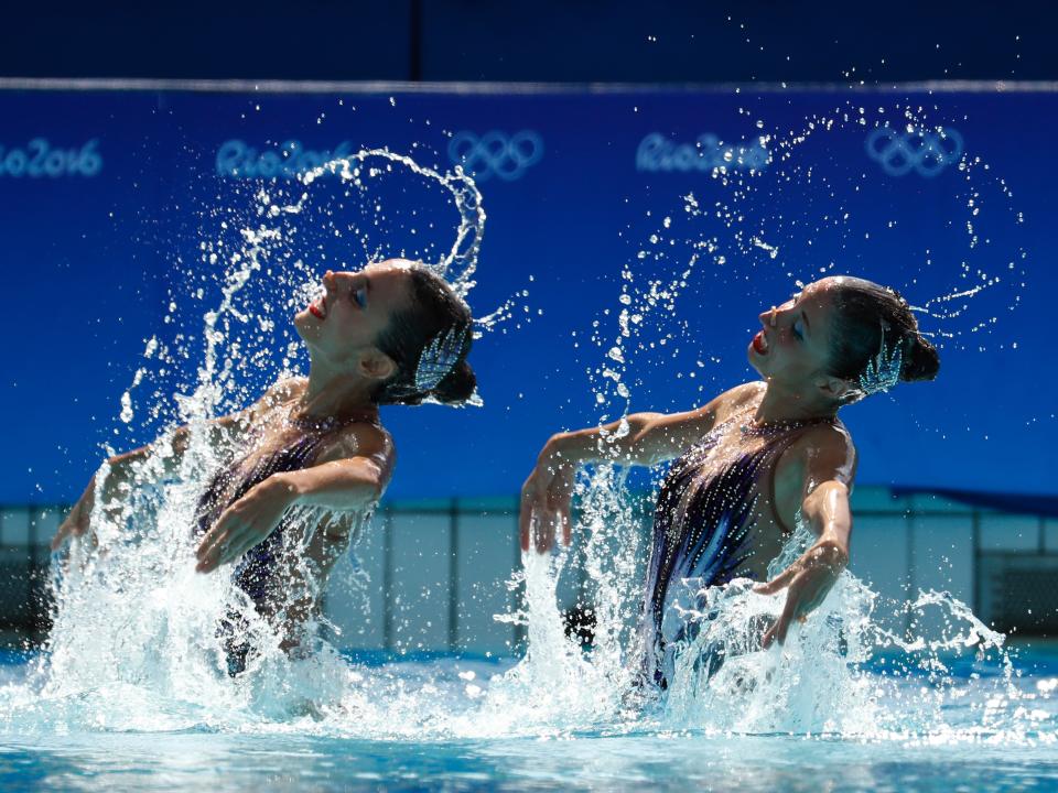 Anna-Maria and Eirini-Marina Alexandri splash out of the water during a synchronized swimming routine