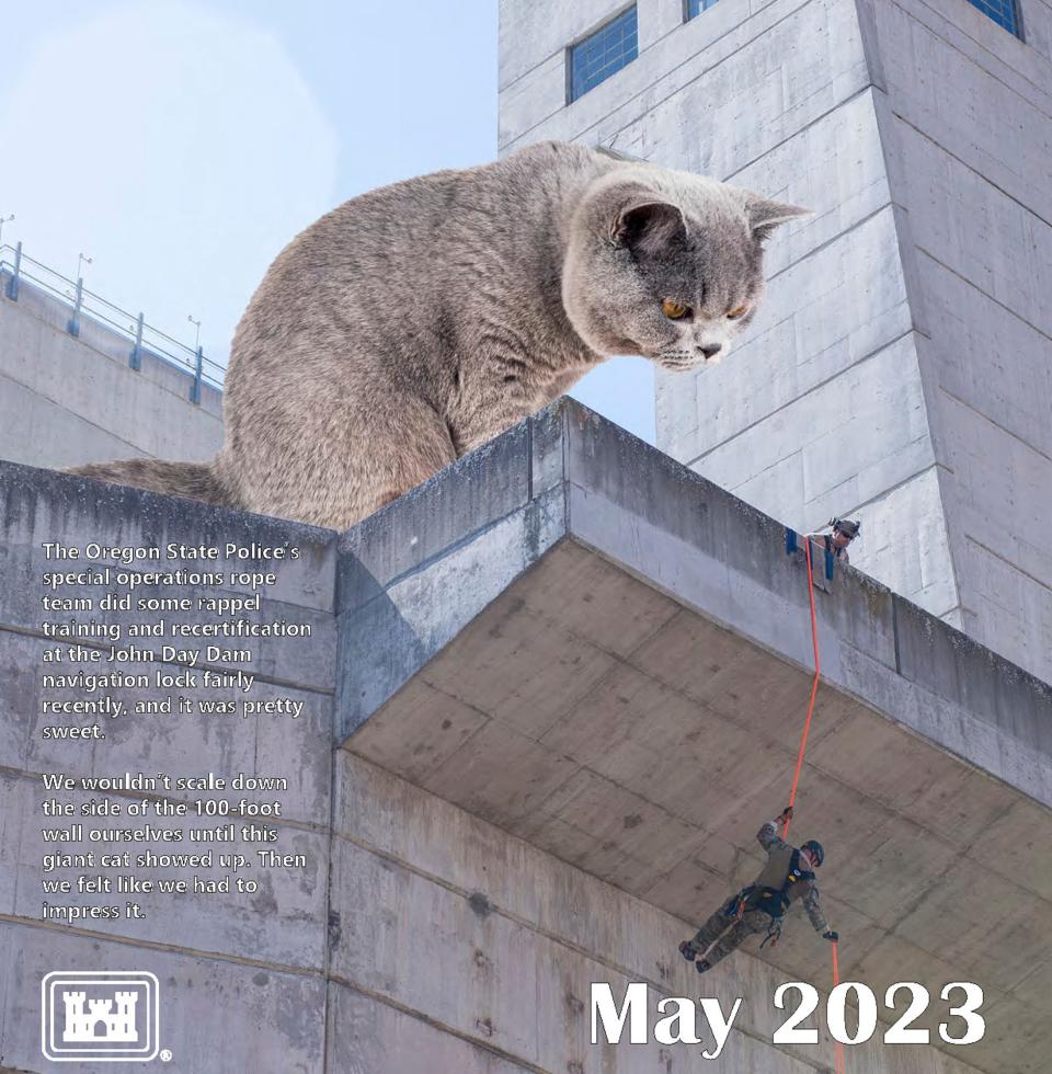 A scene in Rufus, Ore. with a cat photoshopped observing the Oregon State Police’s special operations rope team doing some rappel training and recertification at the John Day Dam, featured in Portland District of the U.S. Army Corps of Engineers' 2023 calendar.