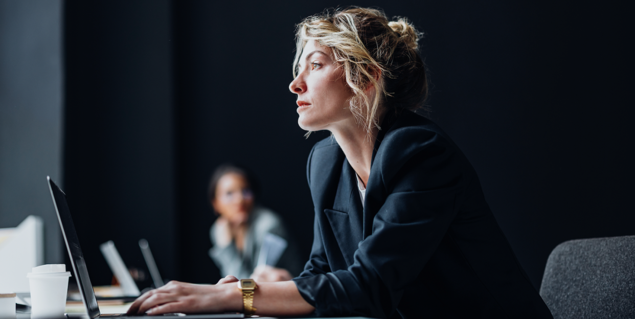 a person sitting at a table working at a laptop