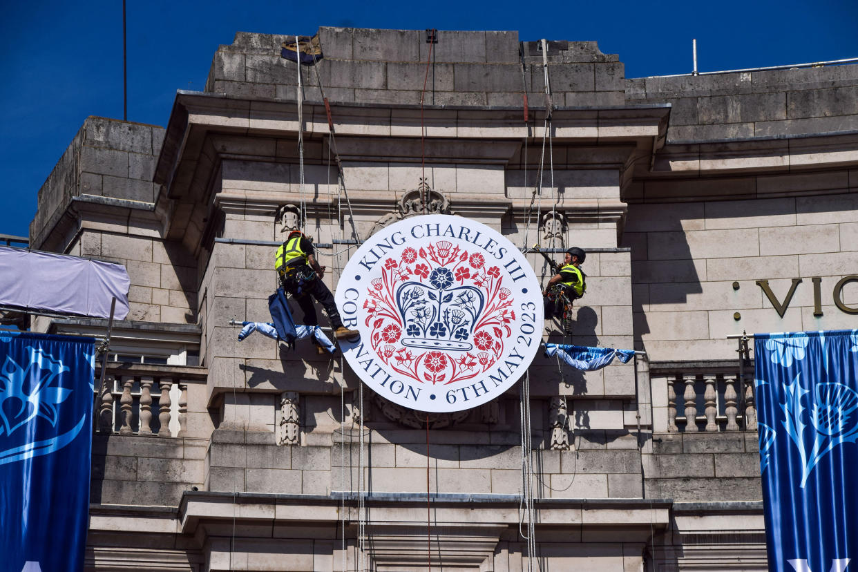 Workers install a huge coronation emblem on the Admiralty