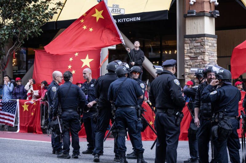 Chinese demonstrators wave flags as police stand by near the Moscone Center in San Francisco on Wednesday. Demonstrations popped up all over the city for the Asia-Pacific Economic Cooperation (APEC) summit as President Joe Biden and Chinese President Xi Jinping met behind closed doors at an estate south of the city. Photo by Terry Schmitt/UPI