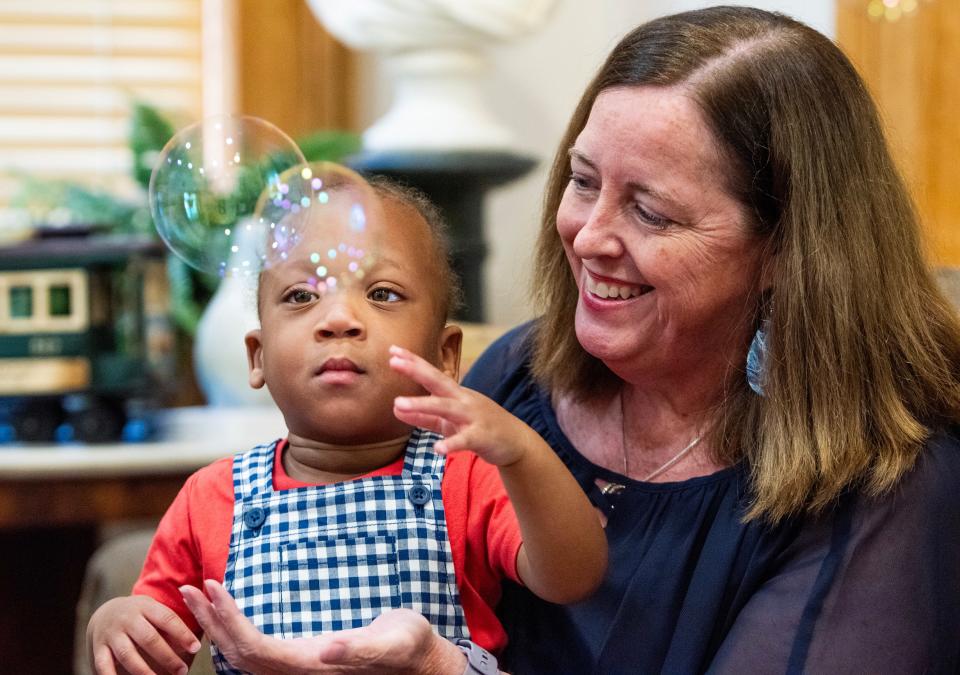 Jenny Savage, regional director of the Alabama Institute for Deaf and Blind, holds Jemaine Jones on April 16 at her office in Montgomery.