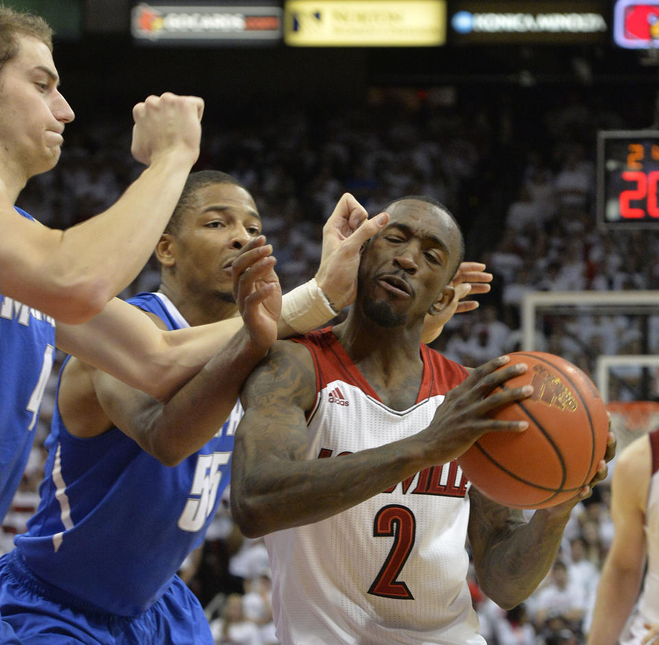 Louisville's Russ Smith, right, is trapped by Memphis' Austin Nichols, left, and Geron Johnson during the second half of an NCAA college basketball game on Thursday Jan. 9, 2014, in Louisville, Ky. Memphis defeated Louisville 73-67. (AP Photo/Timothy D. Easley)