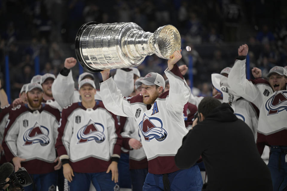 Colorado Avalanche center Nathan MacKinnon lifts the Stanley Cup after the team defeated the Tampa Bay Lightning in Game 6 of the NHL hockey Stanley Cup Finals on Sunday, June 26, 2022, in Tampa, Fla. (AP Photo/Phelan Ebenhack)