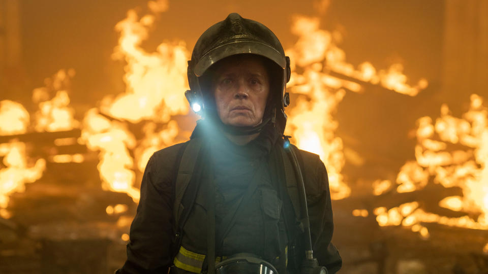 Caroline Proust in her firefighting gear surrounded by flames in Notre Dame