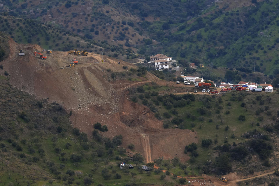 Drill machines and excavating machinery work on top of the mountain, left, next to a deep borehole to reach a 2-year-old boy trapped there for six days near the town of Totalan in Malaga, Spain, Saturday, Jan. 19, 2019. Authorities in southern Spain say that they hope to reach the spot where they believe the two-year-old boy who fell in a borehole six days ago is trapped in approximately 35 hours. The leading engineer coordinating the search-and-rescue operation says Saturday that the estimate depends on everything "going favorably." (AP Photo/Gregorio Marrero)