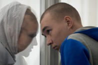 Russian Sgt. Vadim Shishimarin listens to his translator during a court hearing in Kyiv, Ukraine, Monday, May 23, 2022. The court sentenced the 21-year-old soldier to life in prison on Monday for killing a Ukrainian civilian, in the first war crimes trial held since Russia's invasion. (AP Photo/Natacha Pisarenko)