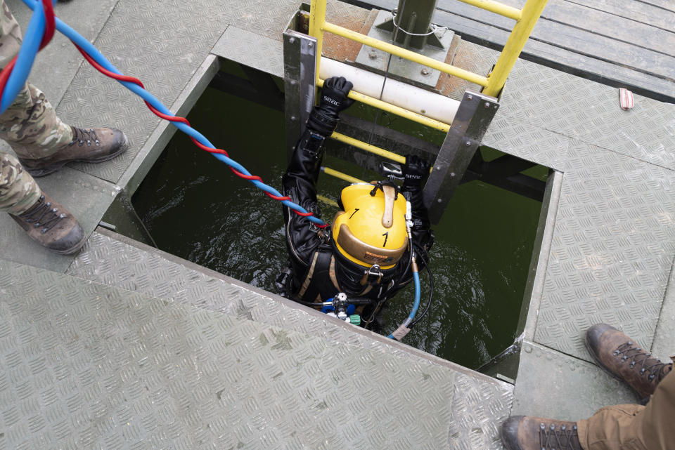 A Belgian military diver is returning to a diving platform on Danube River in Budapest, Hungary, Friday Oct. 13, 2023, during an international training exercise which prepares military divers to find and remove unexploded underwater ordnances. Hungary this year hosted the 10-day exercise for the second year in a row and provided the soldiers from Hungary, Germany, Belgium and Lithuania with hands-on training in a variety of environments, like facing the powerful current of the Danube River. (AP Photo/Bela Szandelszky)