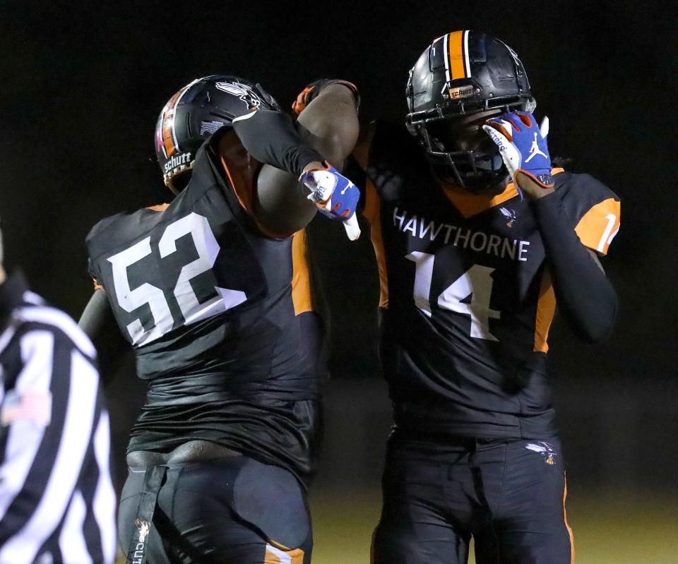 Hawthorne High School defenders Stanley Cooks (52) and Jailen Ruth (14) celebrates after a big stop during a second round game in the 1A playoffs, in Hawthorne, Fla. Aug. 19, 2021. The Hornets beat the Wildwood Wildcats.