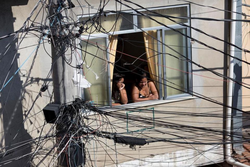 Women watch a protest taking place against the violence between police and gangs.