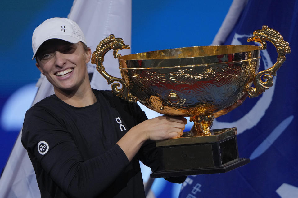 Iga Swiatek of Poland poses with her trophy on stage after winning in the women's singles final match of the China Open tennis tournament at the Diamond Court in Beijing, Sunday, Oct. 8, 2023. (AP Photo/Andy Wong)