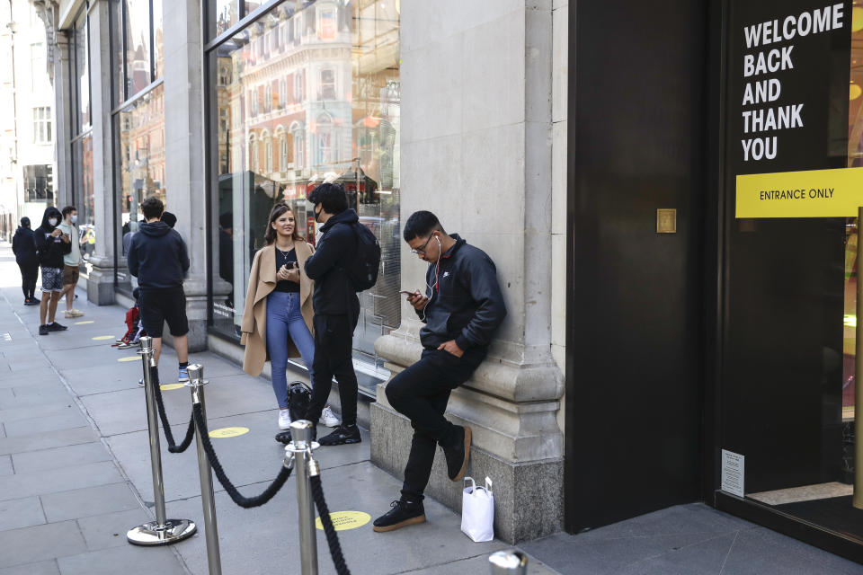 People wait in line for the opening of the Selfridges department store in London, Monday, June 15, 2020. After three months of being closed under coronavirus restrictions, shops selling fashion, toys and other non-essential goods are being allowed to reopen across England for the first time since the country went into lockdown in March.(AP Photo/Matt Dunham)