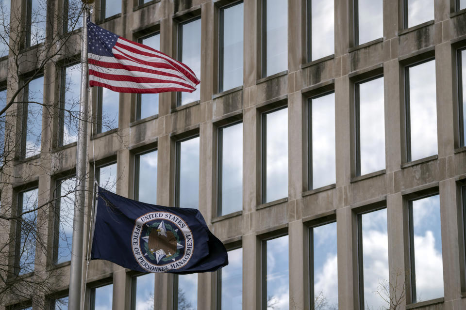 U.S. and agency flags fly outside the Theodore Roosevelt Building, location of the U.S. Office of Personnel Management, on Tuesday, Feb. 13, 2024, in Washington. Former President Donald Trump has plans to radically reshape the federal government if he returns to the White House, from promising to deport millions of immigrants in the U.S. illegally to firing tens of thousands of government workers. (AP Photo/Mark Schiefelbein)