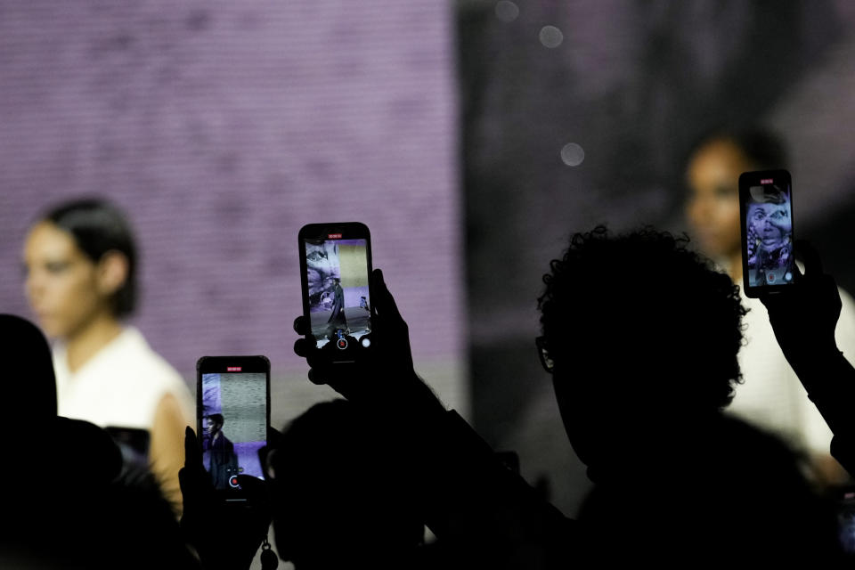 Audience members use their phones during the Dior Haute Couture Spring-Summer 2023 collection presented in Paris, Monday, Jan. 23, 2023. (AP Photo/Christophe Ena)