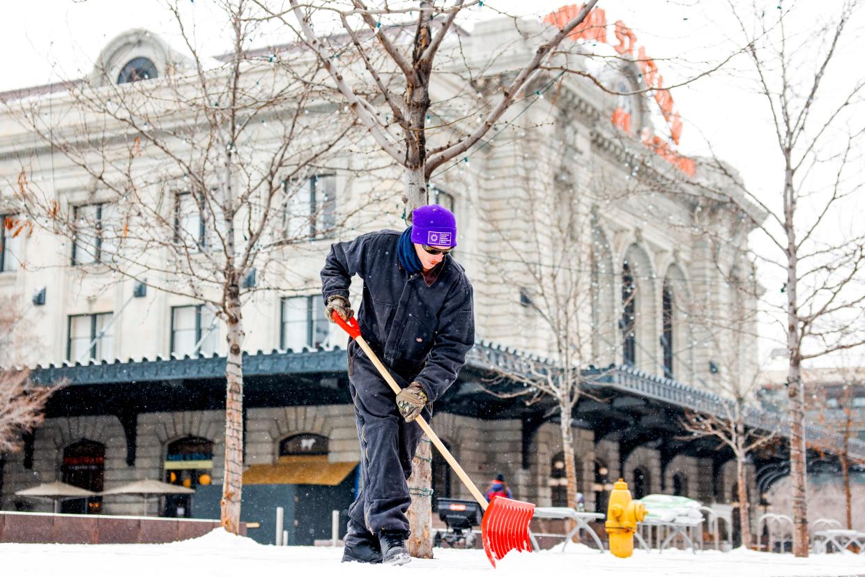 A Downtown Denver Business Improvement District employee shovels the sidewalk outside of Union Station during a winter storm on February 22, 2023 in Denver, Colorado.