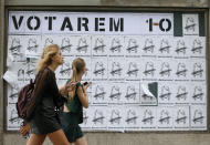 <p>Women walk past a poster reading in Catalan “We will vote” in Barcelona Saturday, Sept. 30 2017. Catalonia’s planned referendum on secession is due to be held Sunday by the pro-independence Catalan government but Spain’s government calls the vote illegal, since it violates the constitution, and the country’s Constitutional Court has ordered it suspended. (Photo: Bob Edme/AP) </p>