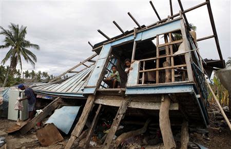 Typhoon victims look out from their house that was damaged by Super Typhoon Haiyan in Bogo, Cebu in central Philippines November 17, 2013. REUTERS/Erik De Castro