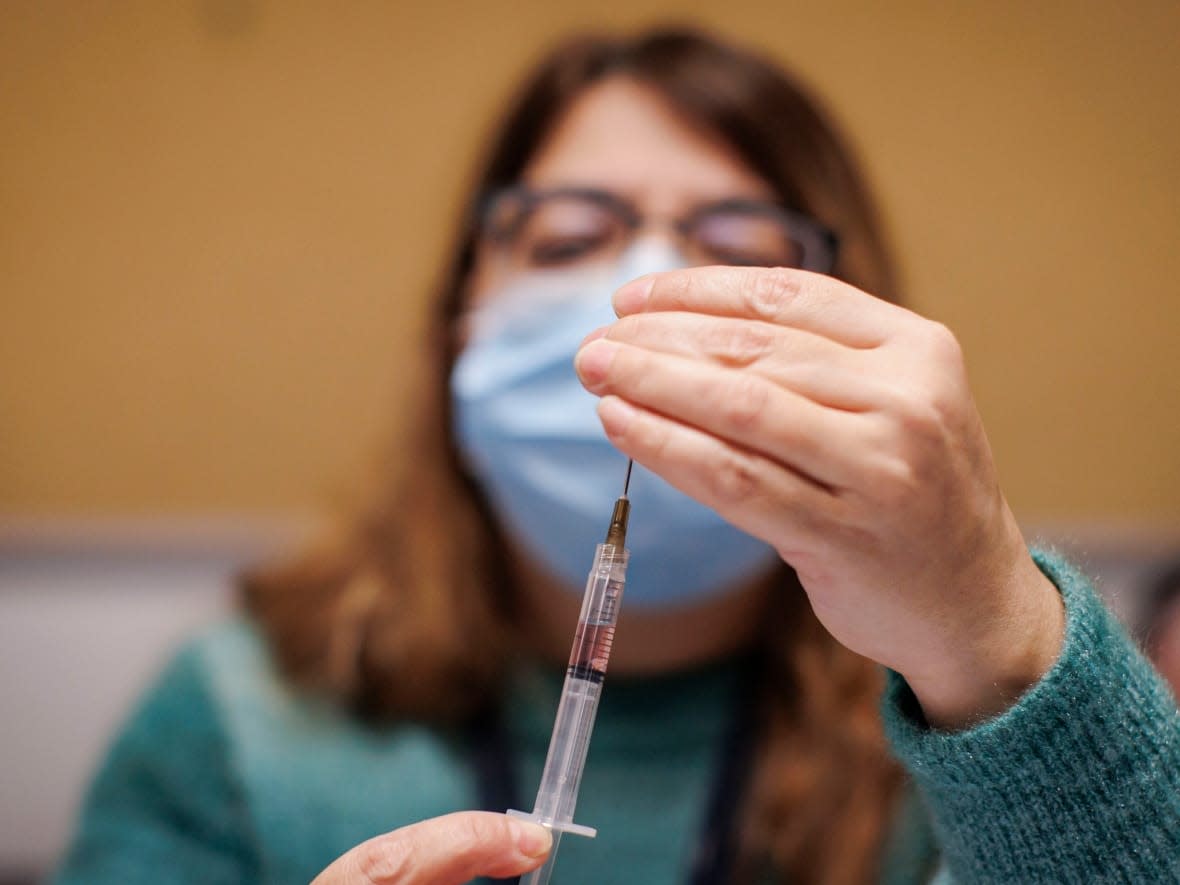 A Toronto Public Health nurse provides vaccinations at a clinic in North York, Ont. Public health officials in Kingston, Ont., are recommending people under age 25 consider the meningococcal B vaccine, which isn't publicly funded for everyone. (Evan Mitsui/CBC - image credit)