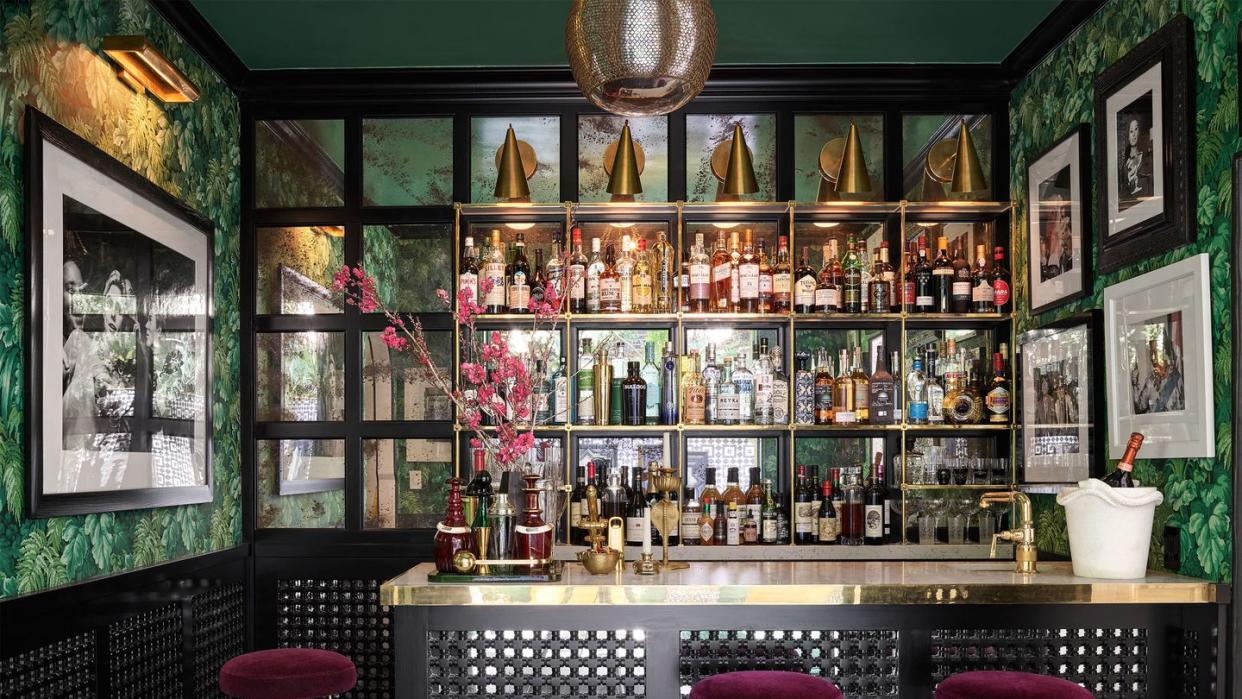 bar with leafy wallpaper and jean royere ﻿barstools