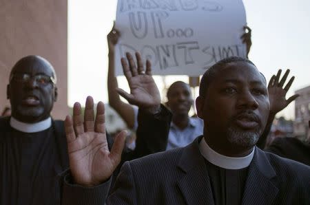 Clergymen shout "Hands up, don't shoot," as they march to the County Prosecutor Bob McCulloch's office to protest the shooting death of unarmed black teen Michael Brown in Clayton, Missouri August 20, 2014. REUTERS/Adrees Latif