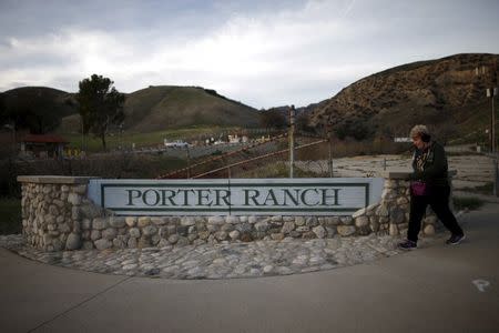 A woman walks past a Porter Ranch sign at the gas company entrance gate near the site of the Aliso Canyon storage field where gas has been leaking in Porter Ranch, California, United States, in this January 21, 2016 file photo. REUTERS/Lucy Nicholson/Files