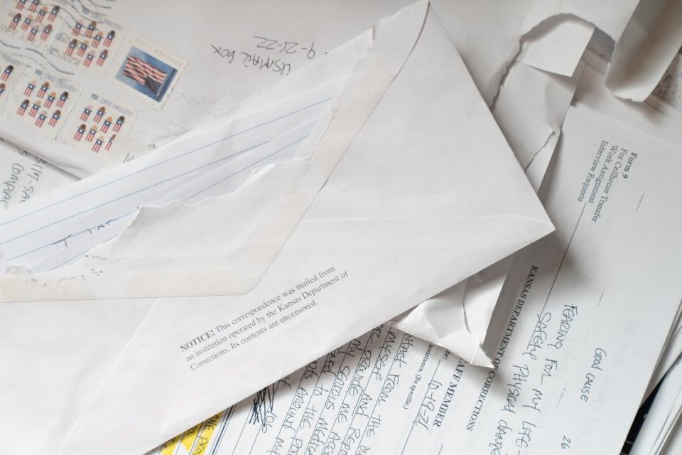 Examples of correspondence from prisoners at the Kansas Department of Corrections is laid on out a table at The Capital-Journal.