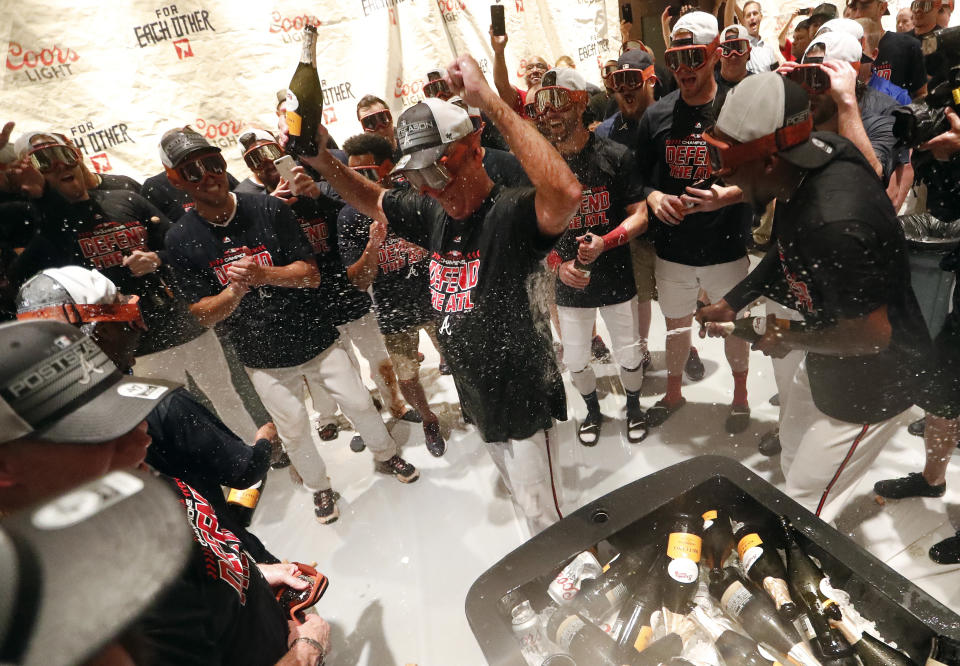 Atlanta Braves manager Brian Snitker, center, is doused by his players as they celebrate after defeating Philadelphia Phillies 5-3 in a baseball game to clinch the National League East Division, Saturday, Sept. 22, 2018, in Atlanta.. (AP Photo/John Bazemore)