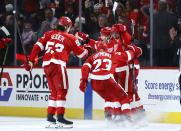 Detroit Red Wings right wing Patrick Kane, second from right, celebrates with teammates Moritz Seider (53), Lucas Raymond (23) and Andrew Copp after scoring in overtime against the Columbus Blue Jackets in an NHL hockey game Tuesday, March 19, 2024, in Detroit. (AP Photo/Duane Burleson)