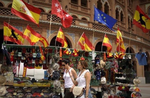 Two women walk past a shop in Madrid, on June 9, 2012. Markets reacted positively in early trading Monday after Spain's leader hailed a eurozone lifeline of up to 100 billion euros ($125 billion) to save the country's stricken banks