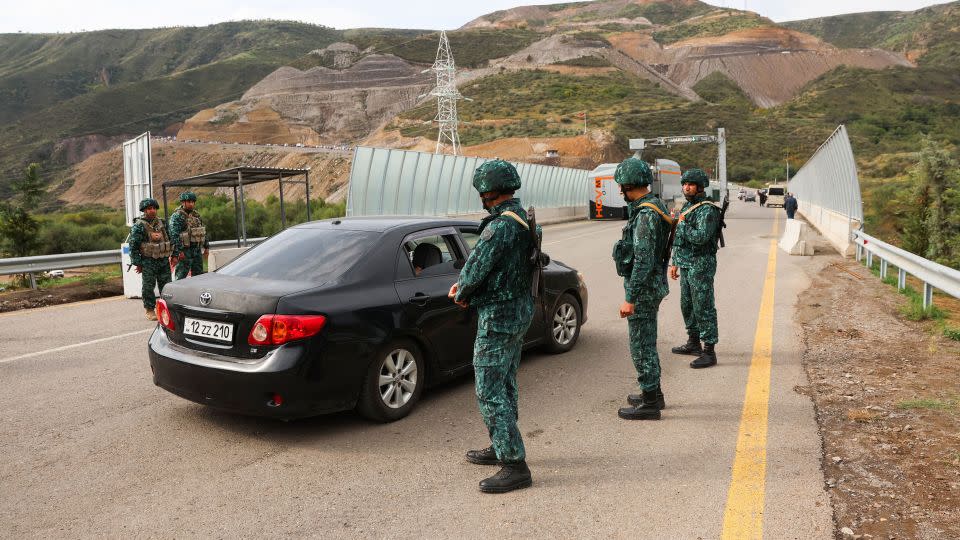 Azerbaijan soldiers stand guard as at the Lachin border station, as cars leave Karabakh to Armenia, on September 26.  - Emmanuel Dunand/AFP/Getty Images
