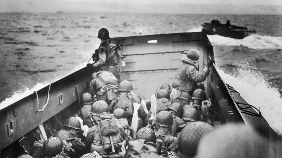 (Original caption) French coast just in front of us.  Helmeted Yankee soldiers crouch tightly behind the bulwarks of a Coast Guard landing ship in the historic journey across the English Channel to the coast of Normandy.  Minutes later, these GI Joes burst through the surf onto the beach under the withering fire of Nazi defenders.  These Coast Guard ships cruised back and forth through D Day, bringing wave after wave of reinforcements to the beachhead.