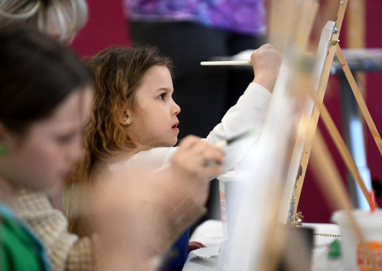 Kaislee Snyder, 4, of Perry Township paints the background on a canvas during an outing to Painting with a Twist in North Canton.