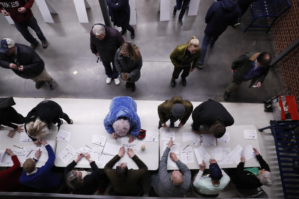 Caucus goers check in at a caucus at Roosevelt Hight School, Monday, Feb. 3, 2020, in Des Moines, Iowa. (AP Photo/Andrew Harnik)